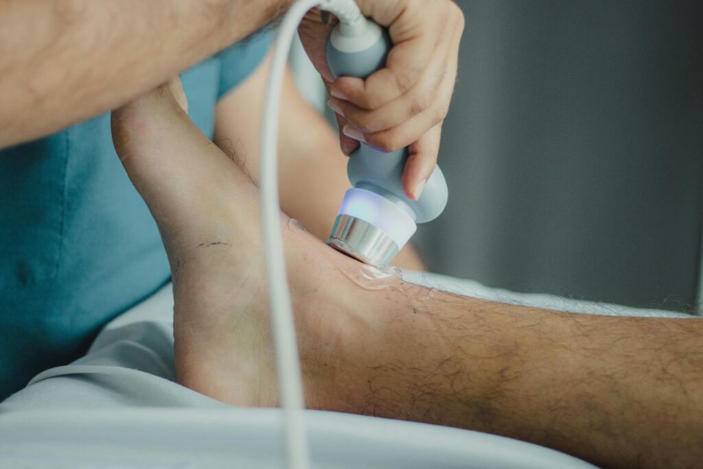 pexels-photo-13185367-13185367 Professional physiotherapist using ultrasound device for leg treatment.